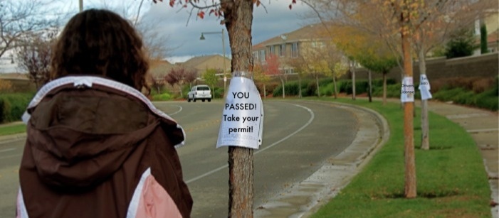 Megan Bauer walking towards the drivers permit sign representing how a permit is the start of a whole new world. Photo by Ariella Appleby taken on Dec. 1.