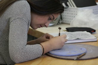 Cameryn Oakes works on her sgraffito tile.