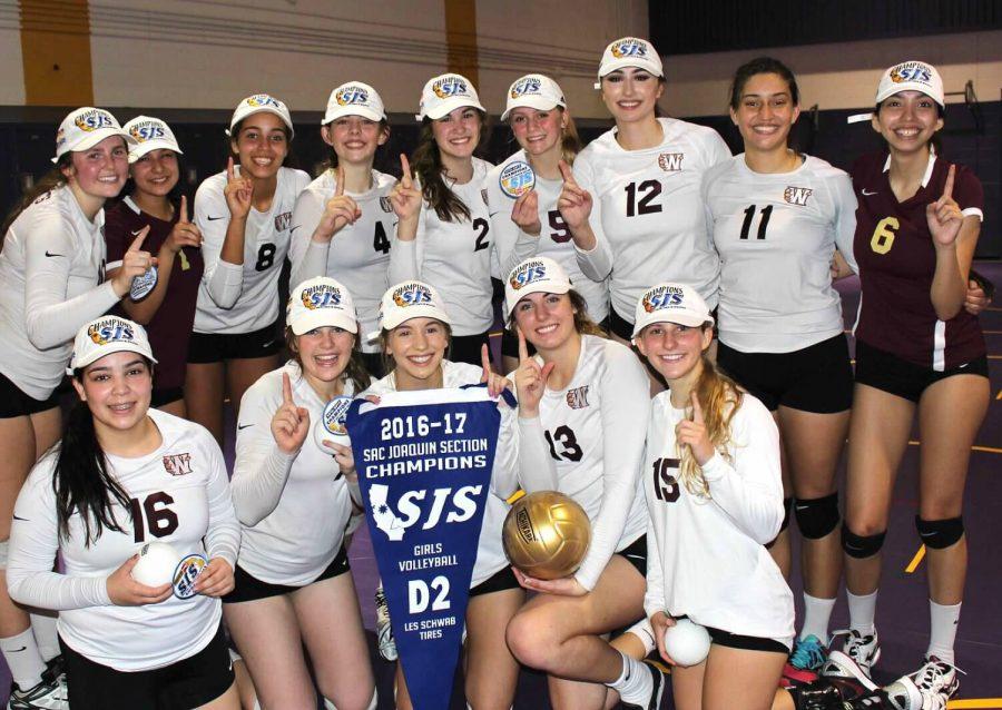 After+receiving+their+championship+hats+and+banners%2C+the+womens+volleyball+team+poses+for+a+team+photo%2C+holding+up+the+number+one.+