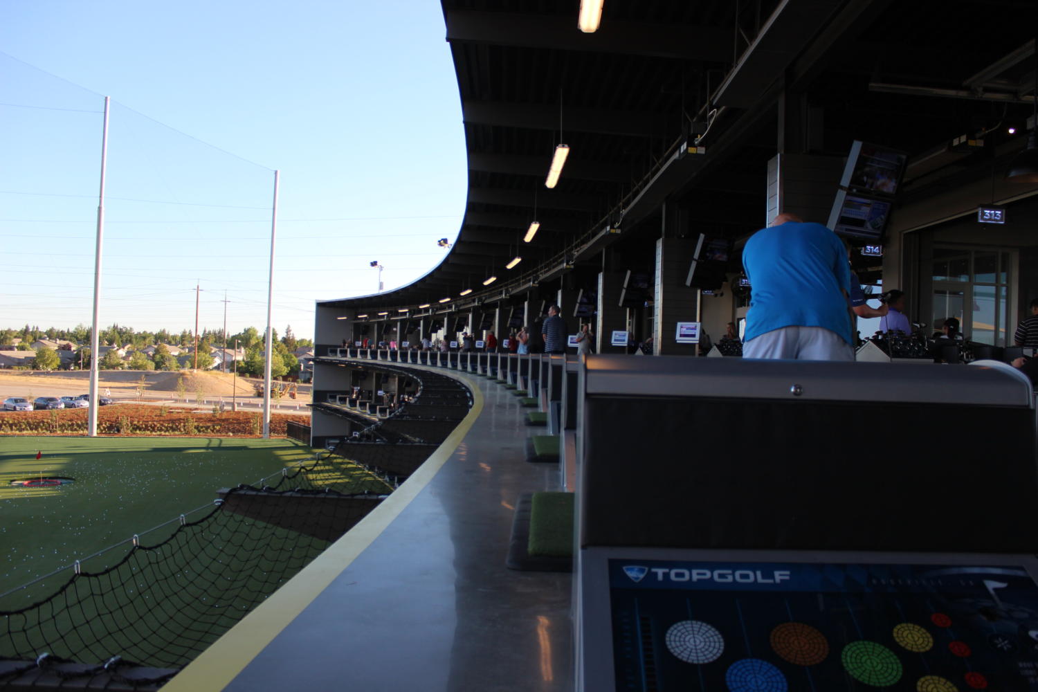 In their individual bays at Top Golf, costumers hit golf balls onto the course. Photo by Emma Thomas