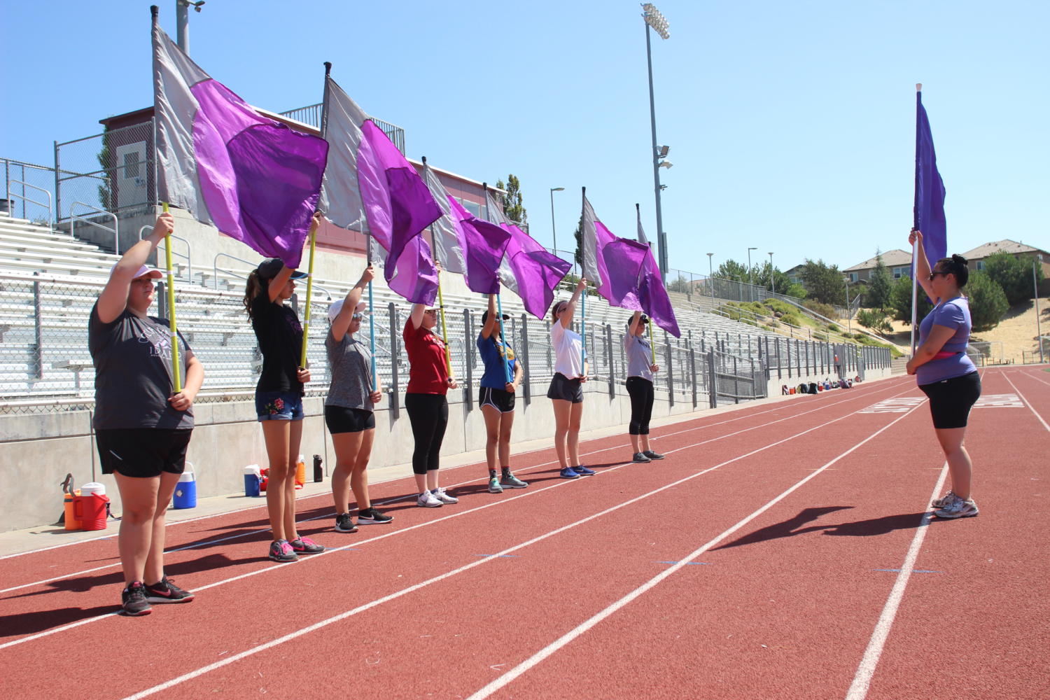 Color+guard+members+practice+movements+with+their+flags+on+the+track+at+band+camp+Aug.+9.+Photo+by+Danica+Tran.+