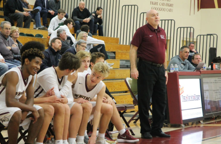 Standing tall, Coach Paul Ackerman watches the game alongside his team playing against Ponderosa, Jan. 23. Photo by Alianna Aviles.