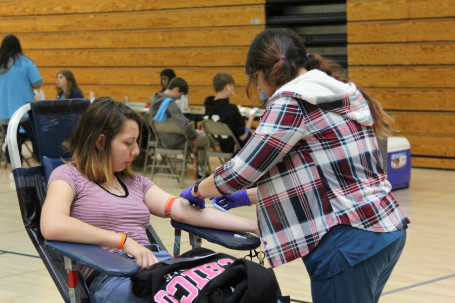 During the blood drive, Laurin Kleiner sits down to make her donation during fifth period. Photo by Giorgia Magnani
