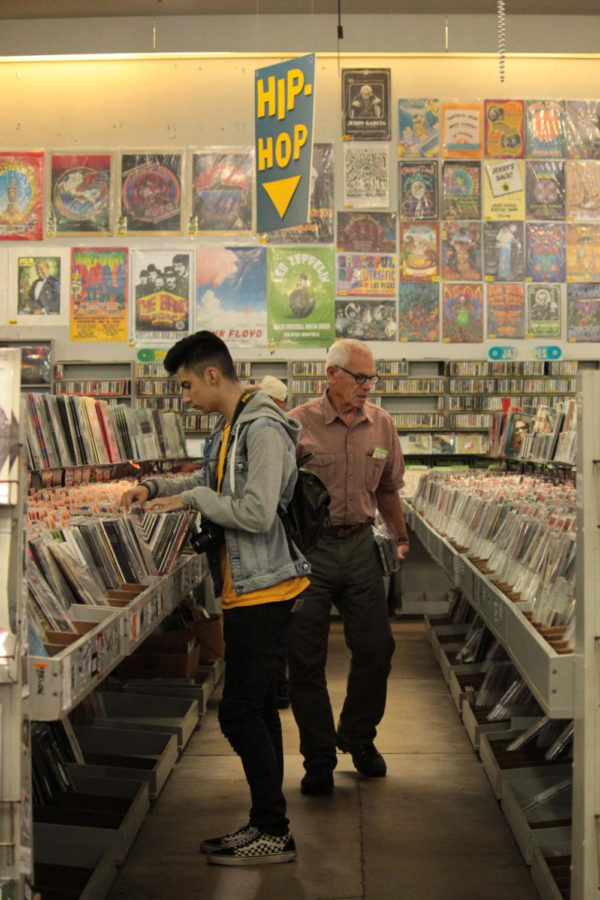 Inside of Amoeba Music, Steven Gutierrez looks through rows of records in search for new music. Photo by Arianna Rasooli.
