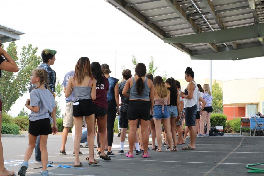 Seniors line up for supplies to paint their parking spots during the 1-5 p.m. paint time.