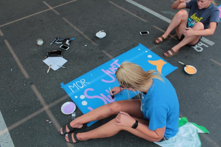 Using purple paint, Morgan Votava writes “Just keeping swimming” on her parking spot, a quote from the movie ‘Finding Nemo’.