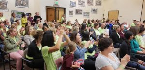 Teachers clap and cheer after hearing a fellow educator share her story working for the district. Photo by Alaina Roberts.