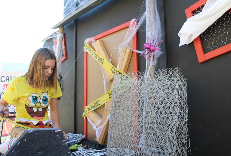 Using the last few hours of Homecoming float construction, Madison Olson works to complete her class’ ‘haunted manor’ themed float. The sophomore class float was haunted hospital, the junior class was haunted cemetery, and the senior class was haunted circus. Photo by Dylan de Valk
