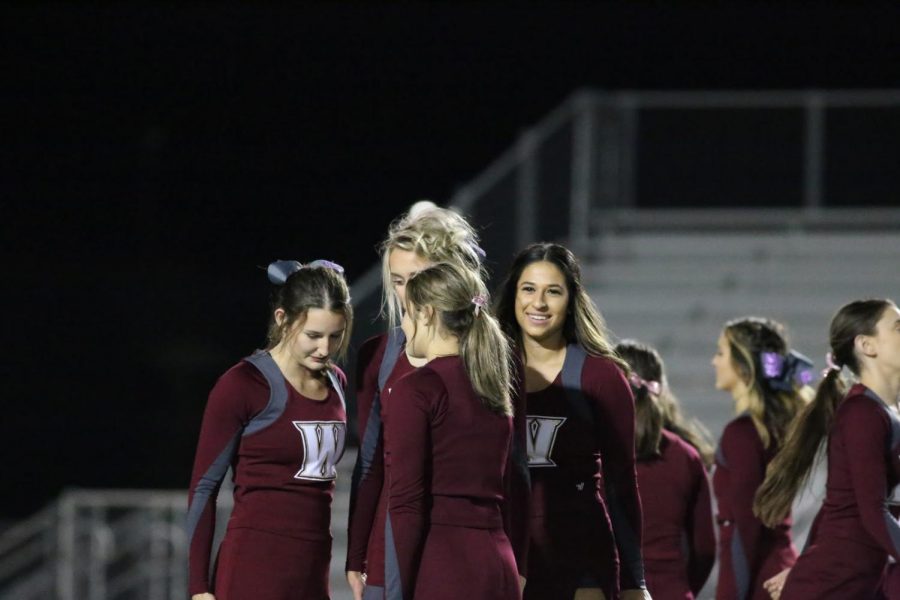 During the last halftime performance of the season Oct. 26, Emily Brustman gets set with her stunt group before partner stunts. This senior night routine was created to focus mainly on the seniors due to this being their last high school game. Photo by Blake Wong.  