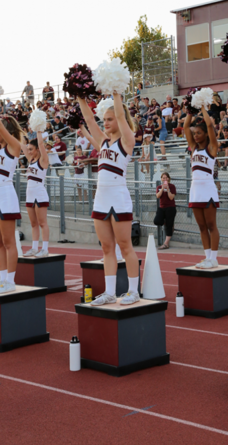 Kara Brent preforms sideline cheers during the very first varsity football game of the season. 