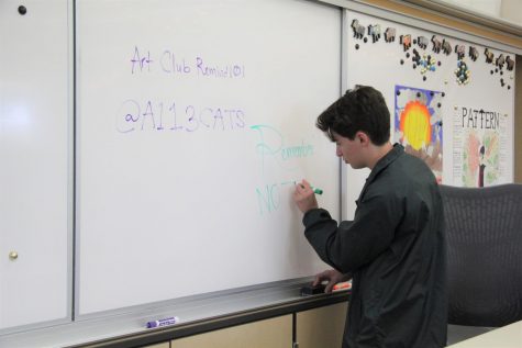 Before the first Maroon Art Club meeting, co-president Jacob Pearsall writes a welcome message on the whiteboard. The introductory meeting on October 3 allowed all students to get to know each other and prepare for the upcoming semester. Photo by Olivia de Lamadrid