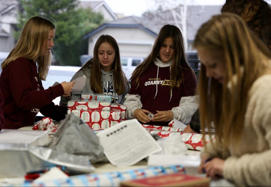 Girls from all levels of soccer meet at Maddie Hamps house to wrap donated presents Dec. 13. Many of the players also donated gifts themselves. Photo by Sofia McMaster