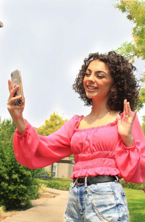 Adalie Bucher waves while FaceTiming her friends outside. Photo by Grace Trammell.