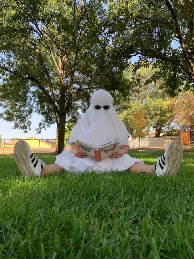 Melanie Garcia dresses as a ghost while reading a book for a TikTok-inspired photoshoot. Photo by Elisha Tapangan.
