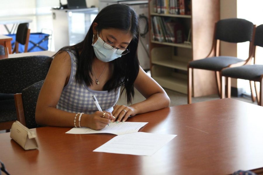 Kiana Kim completes a club application in the library to establish The Human Rights Advocacy Club. Club applications ended Sept. 1.
 Photo by Nikhita Tandon.
