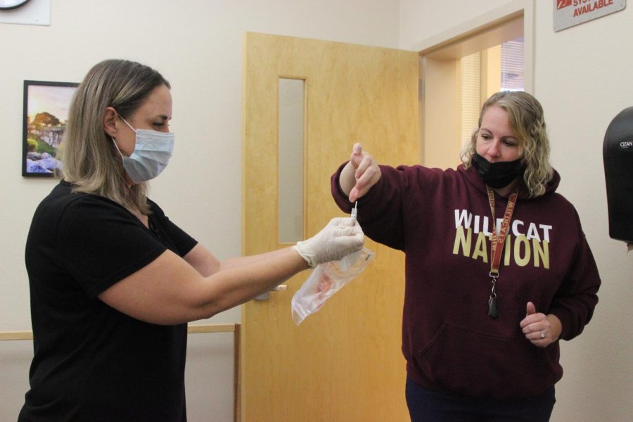 During the first round of staff COVID testing on the week of Oct. 18, principal’s secretary Mrs. Tamara Fernandes hands her swab to RUSD Health Official Mrs. Lindsey Williams for her weekly surveillance test. Photo by Francheska Pontillas.