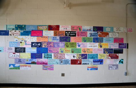 The furthest wall of the dance room is covered in hand-painted bricks by students who graduated after completing the dance program with Mrs. Halley Crandell and Mrs. Mallory Ansley, who are both stepping down as coaches beginning in the 2022-23 school year. Photo by Maya Gomez