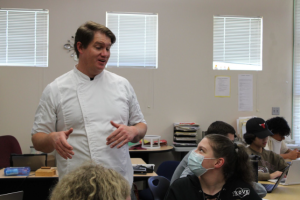 In room F9, Mr. Brian Crammer helps his fifth period Culinary III students with a “Get to Know Me” slideshow. Photo by Allie Bosano.