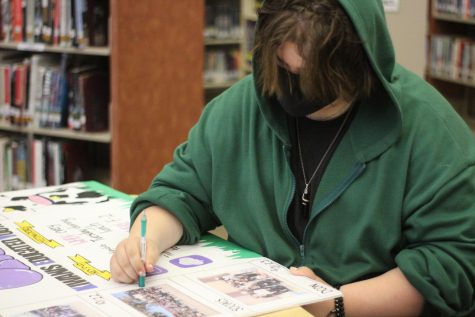 Preparing for Club Rush in the library Sept. 19, Cade George finalizes details on a tri-fold for the Key Club booth. Photo by Jezlyn Sotelo. 