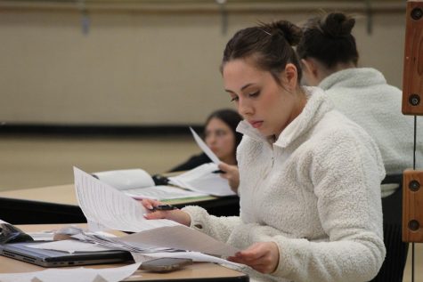 Looking over dance contracts for the spring show, Ms. Arianna Kioski teaches her second day as a long-term substitute for fifth period Dance I. Photo by Reilynn Roux