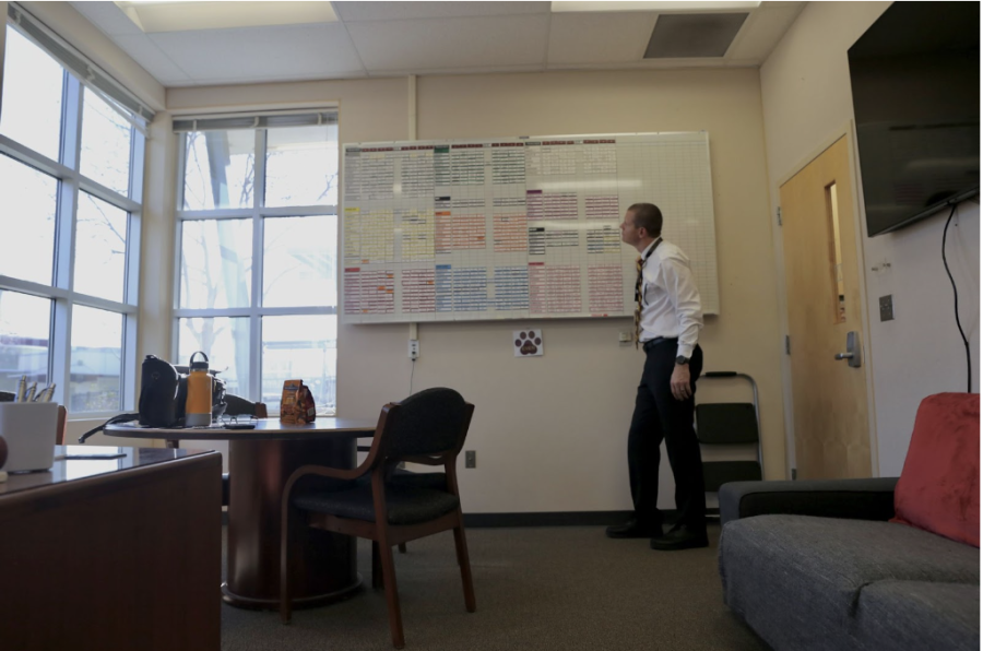 In his office, Principal Mr. Scott Collins reviews the master schedule board. The board contains all classes, also called sections, with their corresponding periods and teachers. As new classes are added over time, administration rearranges and improves the schedule as needed. “We’re working on a lot of new things to try to continue to have a better year and a better master schedule. Classes are a large cultural and academic foundation, and we have to work to make our master schedule better,” Collins said. Photo by Isabella Tomasini.