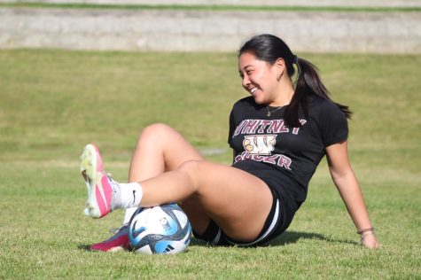 At Margarat Azevedo Park, Christine Louie rolls out with a ball to help the blood flow in her calf after a training session April 14. Louie stretches after every practice due to her Chronic Compartment Syndrome. Photo by Emerson Kibby