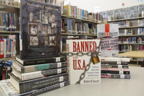In the library, books call attention to the banning of literature about POC and LGBTQ+ in Florida schools. Photo by Liliana Galdarisi.