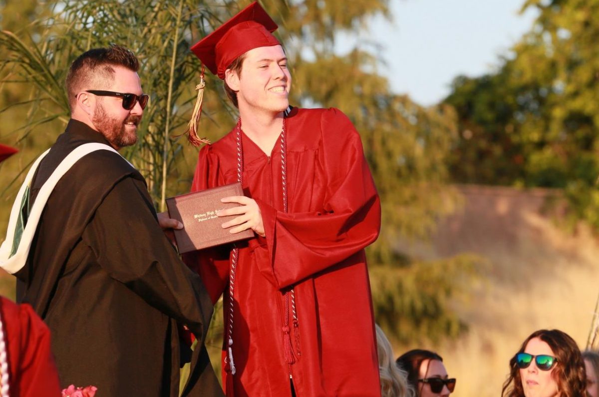 At graduation June 2,  Assistant Principal Mr. Jeff Dietrich hands Matthew Marengo his diploma as they pose for a picture. Commencement was one of Dietrich’s final appearances as he took an assistant principal position at Roseville. Photo by Emerson Kibby