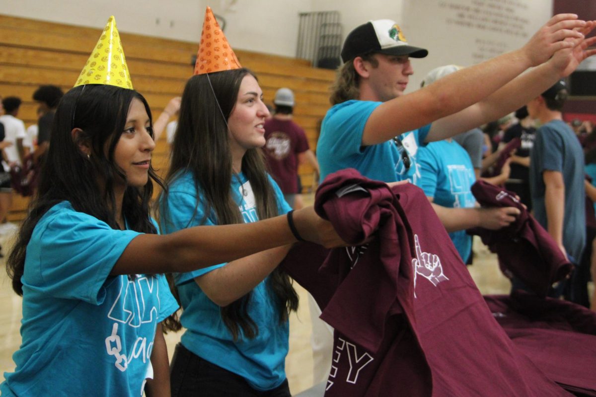 Closing+Freshman+Orientation+Aug.+14%2C+Link+Crew+Leader+Izzy+Soto%2C+Kaylee+Holyoak+and+Tex+Hoehne+hand+out+class+shirts+to+incoming+freshmen.+%E2%80%9CThe+small+room+activities+were+super+fun+and+my+small+group+was+good%2C+they+had+great+conversations%2C+contributed+and+no+one+felt+judged.+It+was+just+a+safe+space%2C%E2%80%9D+Soto+said.+Photo+by+Allie+Bosano.%0A%0A