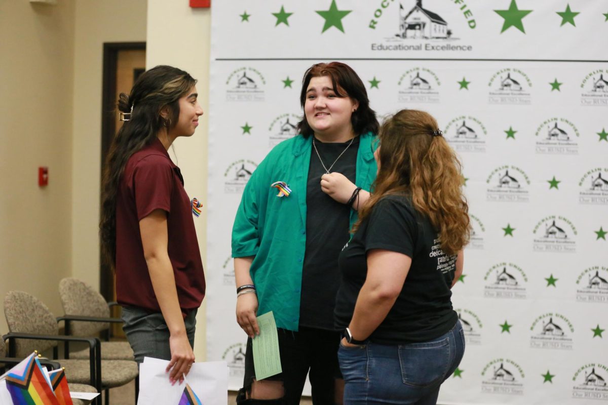 At the school board meeting Sept. 6, ASB President Nayeli Glaude, Cade George and Mrs. Meredith Kane talk about the previous speakers during the first recess. The six-hour meeting included two separate recesses. Photo by Emerson Kibby. 