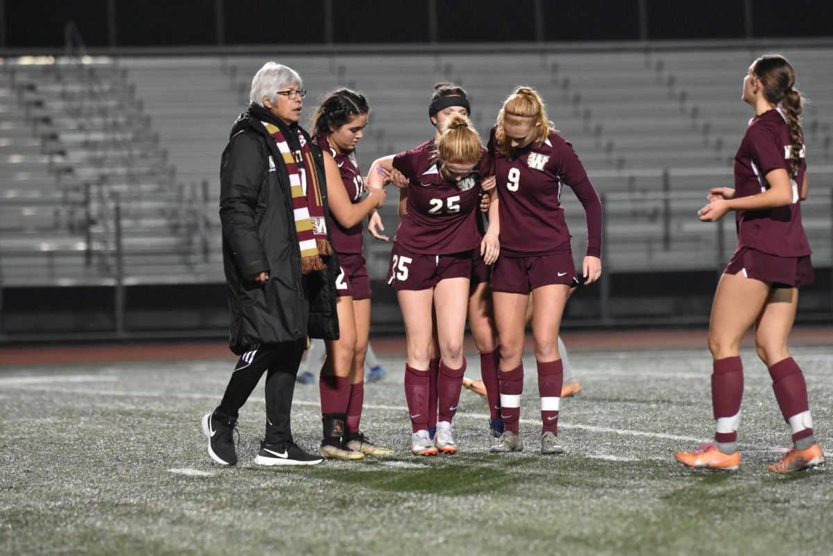 After+hurting+her+ankle%2C+Izzy+Hernandez+gets+help+off+the+field+from+her+teammates.+During+the+women%E2%80%99s+varsity+soccer+game+against+Franklin+Dec+5%2C+Hernandez+is+injured+on+the+field+causing+her+to+need+help+to+walk.+The+game+ended+with+a+score+of+2-1%2C+Franklin.+Photo+by+Caitlyn+Arca.