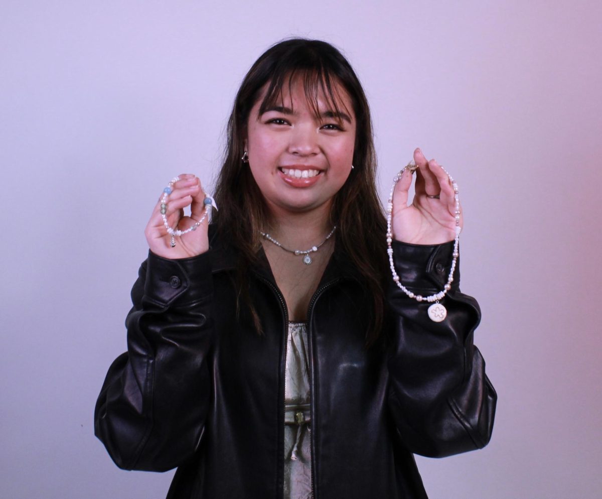 August Donios poses with her handmade jewelry items. Photo by Sydney Hadfield