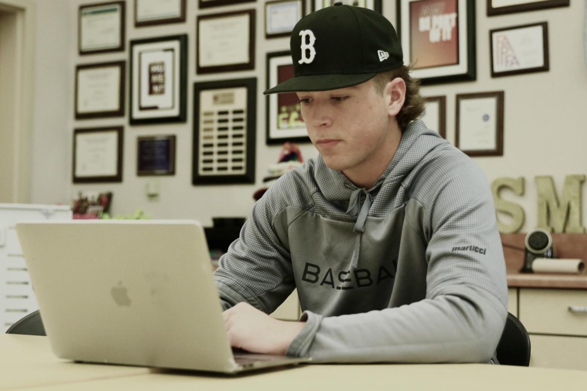 During break, Cameron Duncan uses Adobe Premiere Pro to edit clips from the CIF State D2 Semi-Final Basketball game Oakland Tech against Oakland High March. 5. Photo by Julia Leveron Hidalgo.