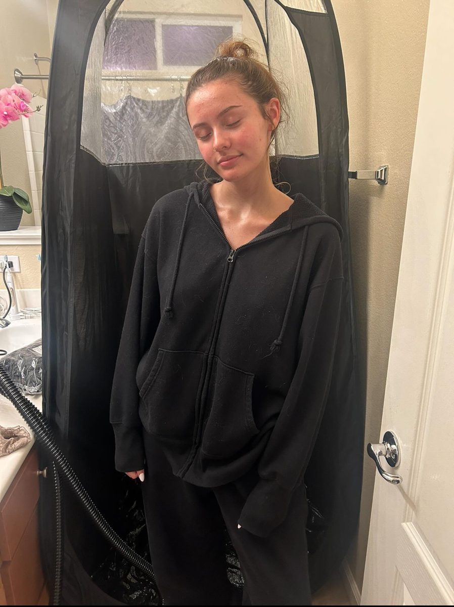 After receiving a spray tan from Payton Dean, Allyssa Tucker poses in her bathroom for a photo to be posted on Dean’s business Instagram @bronzedbabez.tanning Feb.12. Photo by Payton Dean.