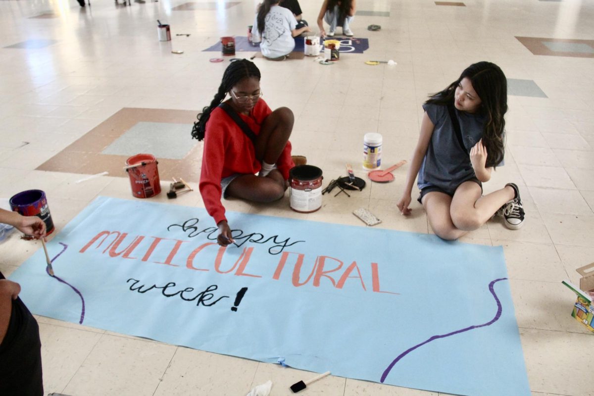 To+promote+Multicultural+Week+April+21+Destinee+Kombo+and+Rebecca+Alferos+paint+a+poster.+From+9%3A00+to+noon%2C+members+from+Black+Student+Union%2C+Asian+Youth+Leadership+Association%2C+Multicultural+Club+and+Hispanic+and+Latin+Culture+Club+help+set+up+by+designing+banners%2C+chalking+the+sidewalk+and+setting+up+decorations+on+trees+on+campus.+