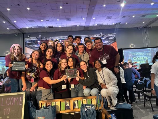 Displaying the Outstanding Leadership Program Award and the Excellence in Service Award at CASL, 19 leadership students and Mr. Jesse Armas pose. Photo by Mrs. Kari Ustaszewski. 